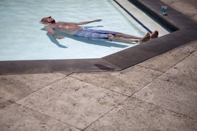 man subermeged in baby pool in the summer heat of californai