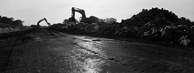 Two excavators clear away stones on what will become I-265.