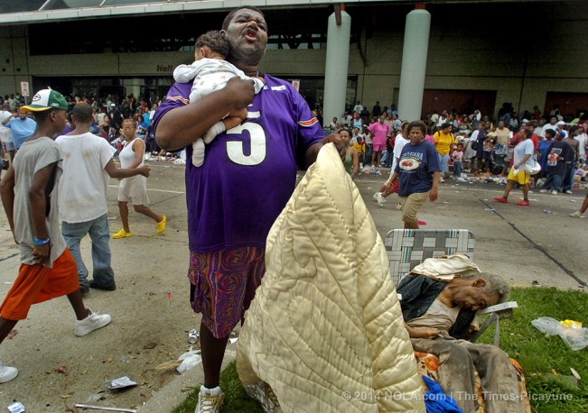 STAFF PHOTO BY TED JACKSON A man with his baby cries out over the body of an elderly man who died in a lawn chair where on the neutral ground of Convention Boulevard as refugees crowd into the Earnest Morial Convention Center with no officials, food, water, or other essentials. They were hoping for busses to come and evacuate them from the city.  Hurricane Katrina. MY THOUGHTS New Orleans is a place of beguiling charm, stealing your heart with vivid images of beautiful oaks, stately mansions, and quaint streetcars. But now, who will soon forget the scenes of  bodies lying in the medians of grand boulevards. this is another trauma we New Orleanians now live with. Thursday, Sept 1, 2005