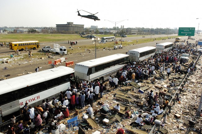 STAFF PHOTO BY ELIOT KAMENITZ As helicopters rush off with the most desperately ill, throngs trapped for nearly a week in New Orleans climb aboard busses at the intersection of I-10 and Causeway Blvd., Saturday, September, 3, 2005, five days after Katrina made landfall.