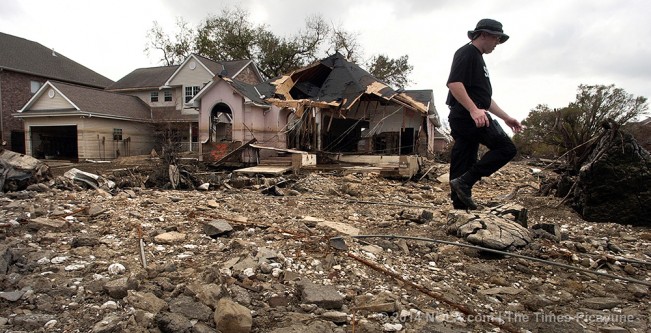 STAFF PHOTO BY JOHN MCCUSKER.  A security worker walks past destroyed houses in Lakeview near the break in the 17th street canal. The two sides of the 17th street canal: Bucktown vs. Lakeview. Shot Thursday September 22, 2005.