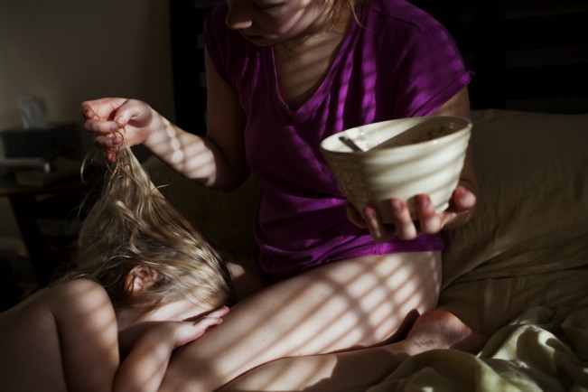 Melissa Eich plays with her daughter Madelyn's hair in the morning while eating breakfast on November 20, 2011 in Norfolk, Virginia.