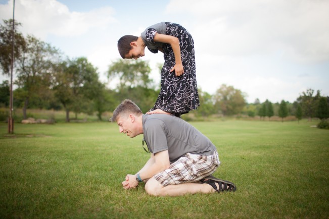 A child plays leapfrog with his father.