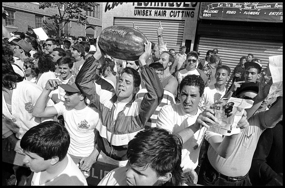 Bensonhurst residents hold up watermelons to mock African American protestors who took to the streets of the largely Italian neighborhood in Brooklyn following the acquittal of Bensonhurst resident Keith Mondello in the shooting death of 16-year-old African American Yusef Hawkins on May 19, 1990. Hawkins, who had gone to the neighborhood to look at a used car, was met by a white mob and shot to death. © Ricky Flores