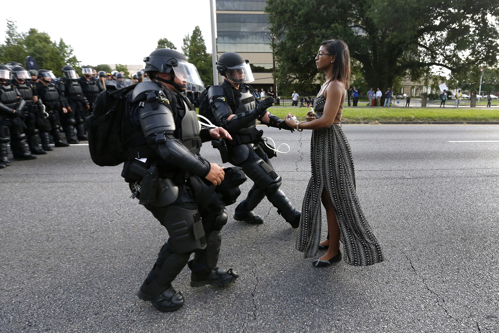 Lone activist Ieshia Evans stands her ground while offering her hands for arrest as she is charged by riot police during a protest against police brutality outside the Baton Rouge Police Department in Louisiana, U.S.A. on July 9, 2016. Evans, a 27-year-old Pennsylvania nurse and mother to a young boy, traveled to Baton Rouge to protest the shooting of Alton Sterling, a 37-year-black man and father of five, who was held down by two white police officers and shot at close range by one of the officers. The shooting, captured on cell phone videos, aggravated the unrest that has coursed through the United States for two years over the use of excessive force by police, especially against black men. REUTERS/Jonathan Bachman