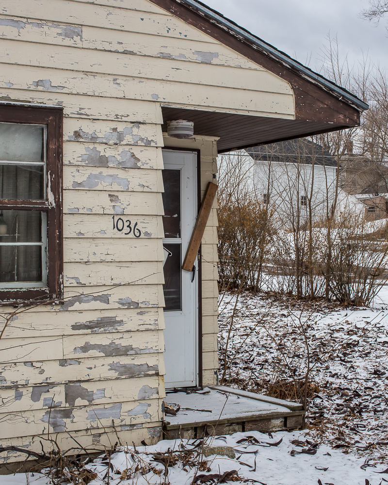 The door to an abandoned house is sealed with a board on Thursday, January 16, 2014, in Webster City, IA.