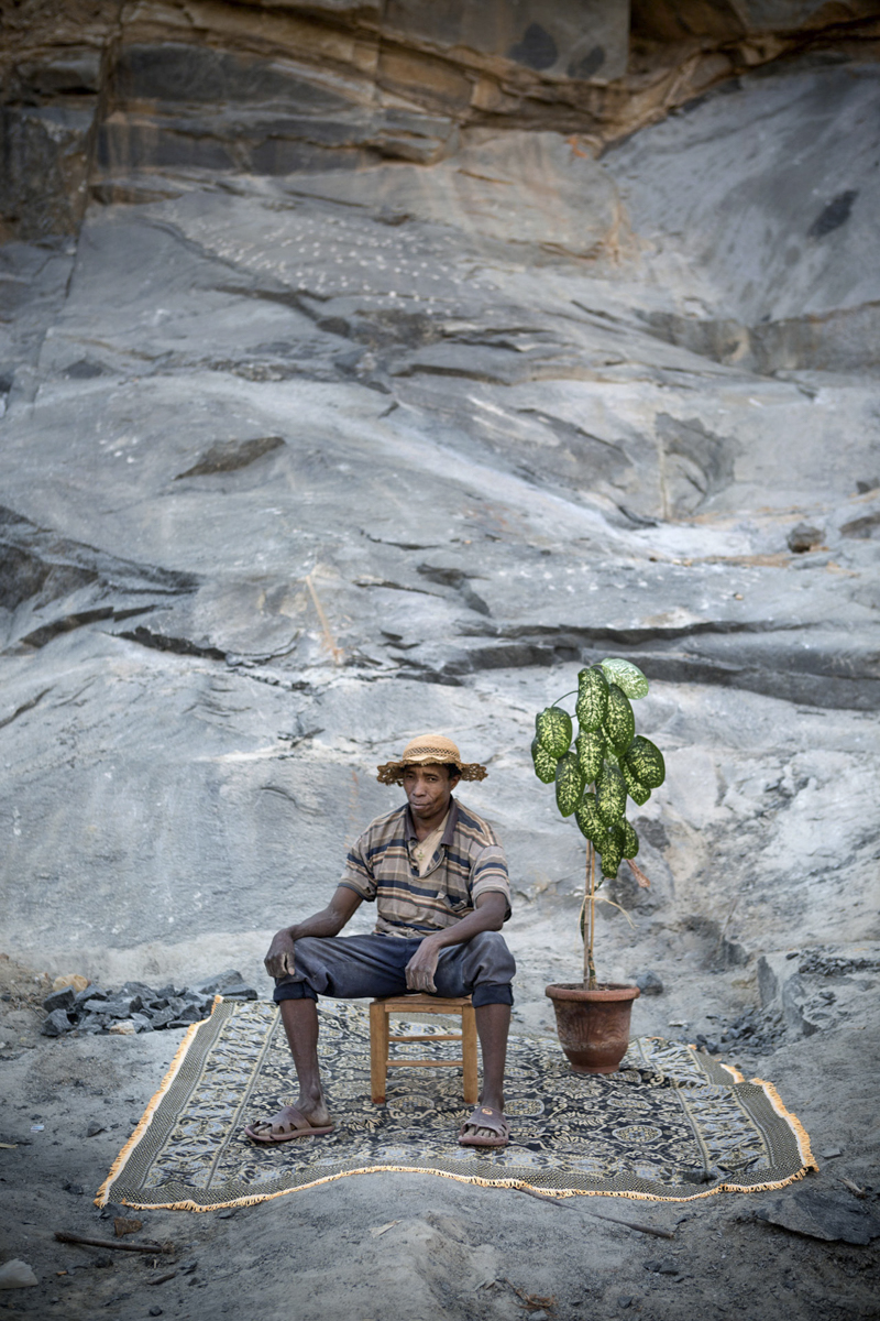 Jaspera Rahatavola, a worker at the Ambohitrombihavana granite rock quarry, outside of Antananarivo, Madagascar poses for his portrait at a temportary studio. From the on-going photographic project, 'Street Studios' which creates outdoor portrait studios on street corners and in public spaces, inviting passing families and individuals to pose and have their picture taken free of charge. The photograph is then printed on site with a portable photo printer so it can be taken home for the family album. So far the project has travelled around South Africa, the DR Congo and Madagascar.