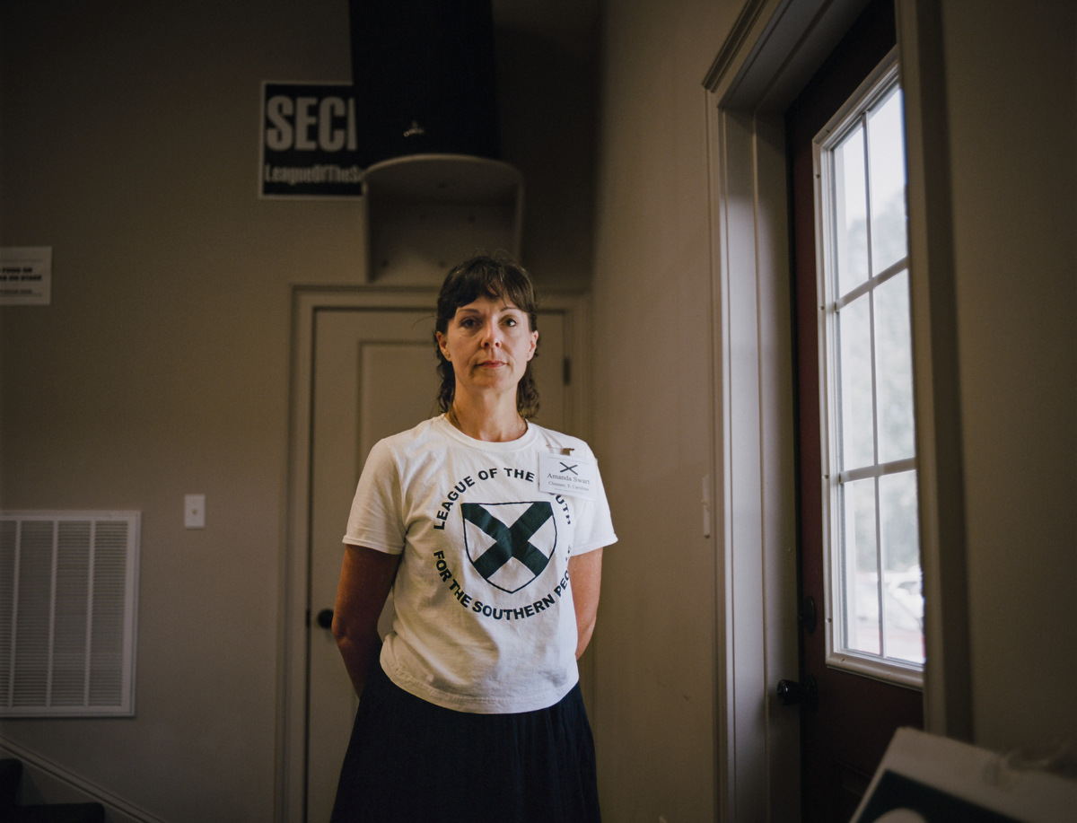 Amanda, the "den mother" of the League of the South, a neo-confederate group that publicly advocates for southern succession, and privately endorses slavery. This portrait was made at their annual convention in Wetumpka, Alabama on June 30, 2017. The League of the South takes great pains to distance itself and differentiate from the KKK, yet promotes many of the exact same ideas under a different outward facing rhetorical stance. The argument about ÒopticsÓ pits different hate groups against each other as they vie for local power. LOS is almost completely male in its power structure and women like Amanda can only play informal roles. Amanda is not from the south but when she met her now husband online as his nutritionist and moved to Mississippi to be with him, she joined. She said that all the people at the meeting (which did include Klan members) were the greatest people sheÕd ever met. This reporter was forcefully ejected and escorted out of the meeting without clear cause.