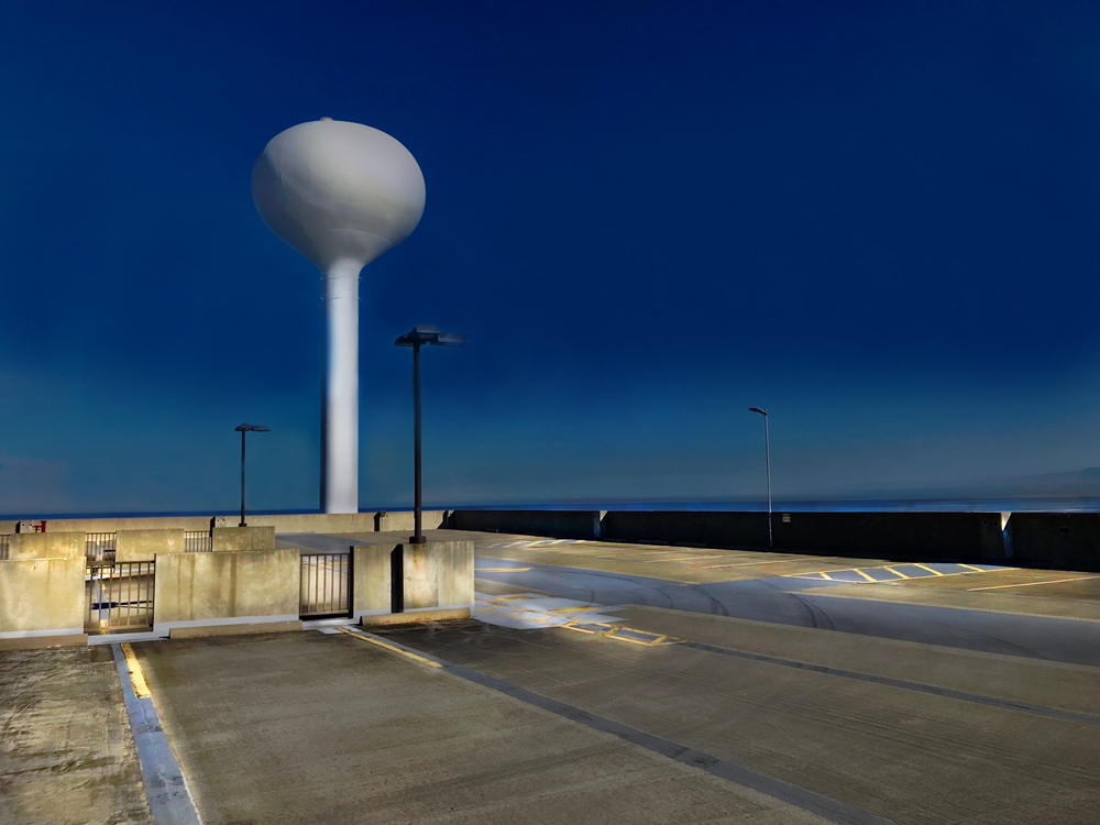 Color photo of the top floor of a parking garage and water tower in Lakeshore, Mississippi.