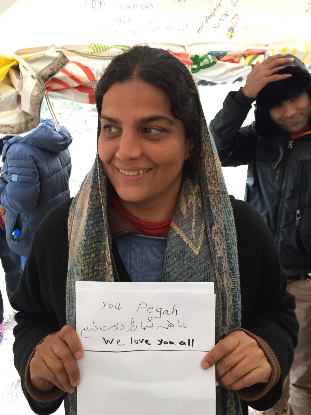 @ Wayne Martin Belger, Afghani woman holding up her "Words from the Heart" after "Us & Them" photo shoot in the Moria refugee camp in Lesbos, Greece.