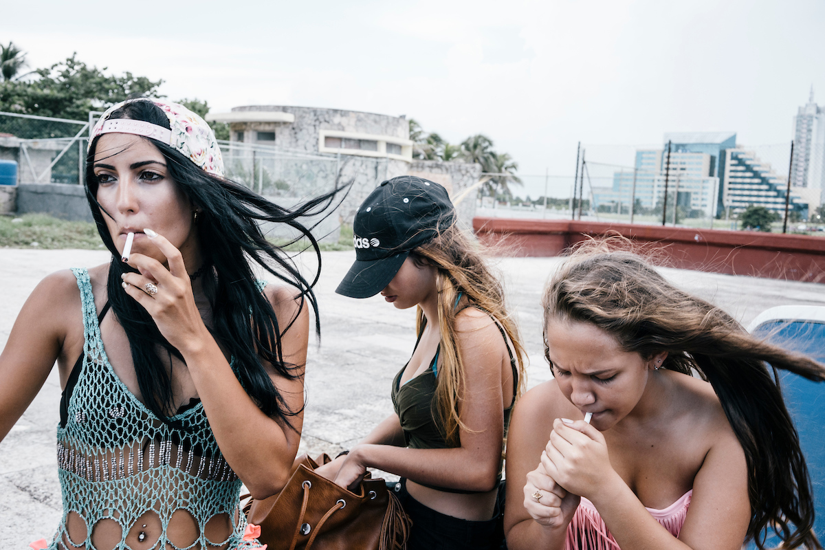 Cuban teens have a smoke during a pool party at Miramar Chateau, a hotel near the beach in Havana.