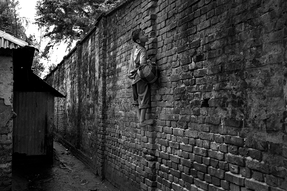Bangladeshi children are regularly employed by smugglers to transport merchandise from one point to another along the border wall. The risks are huge, but the meagre reward, 1 to 3 euros per trip, is a considerable sum for these children from extremely poor families. West Bengal province, India.