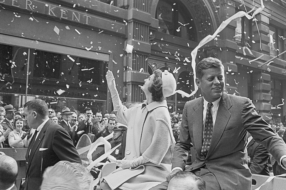Presidential candidate John F. Kennedy rides on a car with wife Jackie in a ticker tape parade. The parade followed the "Canyon of Heroes", the Wall Street area of Manhattan, and was an important part of Kennedy's campaign tour.