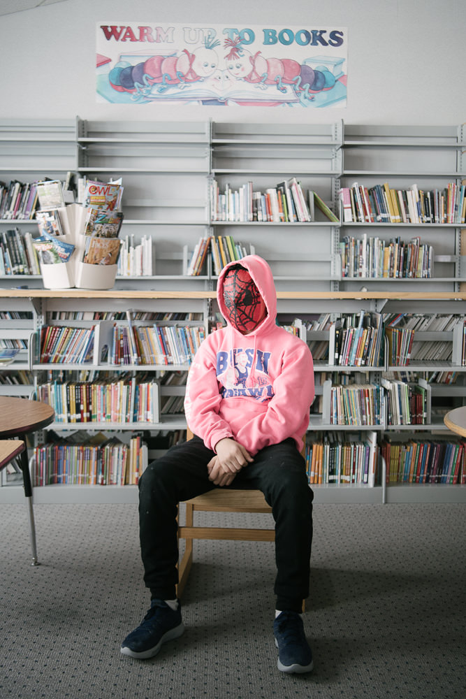 AB poses with his hope mask at the Gambell School Library. Globalization has brought Western popular culture to Saint Lawrence Island through television and internet, offering glimpses of another world while denying access to that world. April 12, 2018, Gambell, AK.