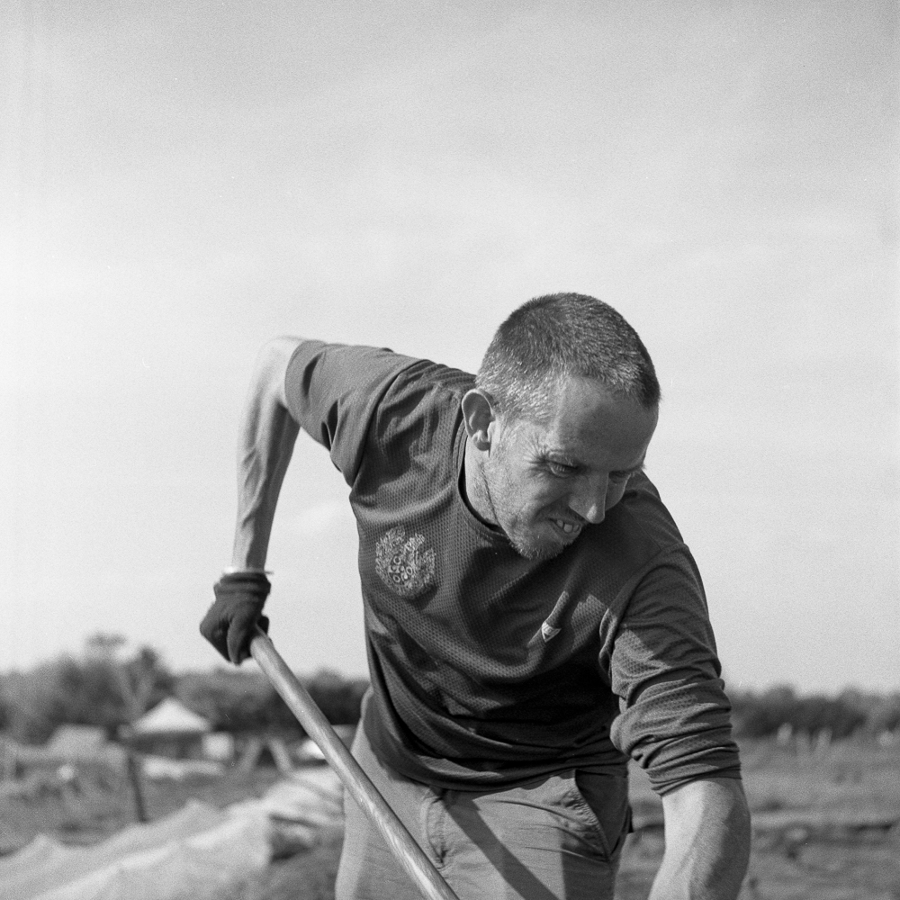 Cris (Crispin) Ricketts raking soil ready for planting at Farnham Community Farm in Runfold, Surrey