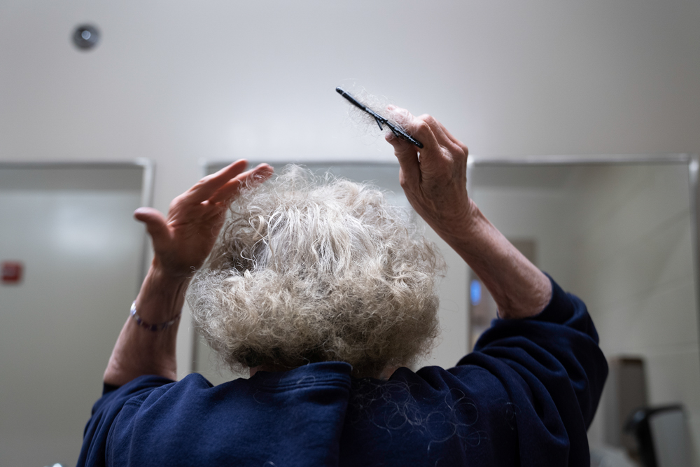 Kathy Tyler, an 82-year-old woman incarcerated at Iowa Correctional Institution for Women in Mitchellville, Iowa, combs out her hair in the shared bathroom around the corner from her cell.