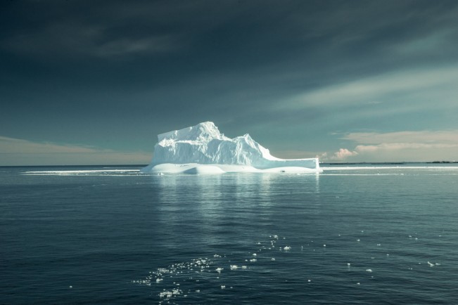 An iceberg several kilometers long floats in the then calm waters surrounding the Antarctic peninsula.