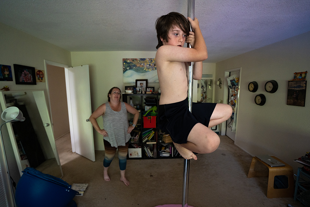 Ryley, the middle son, scales to the top of Siobhán’s dance pole in the master bedroom. Siobhán stumbled into pole dancing in January of 2019 when she saw a new studio in her small town, “Entangled and Sway,” that she thought was for tango classes. After realizing what it really was, she decided to go for it anyway, thinking it’d be a fun way to reclaim her body after such a destructive pregnancy. She became hooked and now dances three times a week in addition to the practice she does on the home pole her husband Jason bought for during the pandemic.