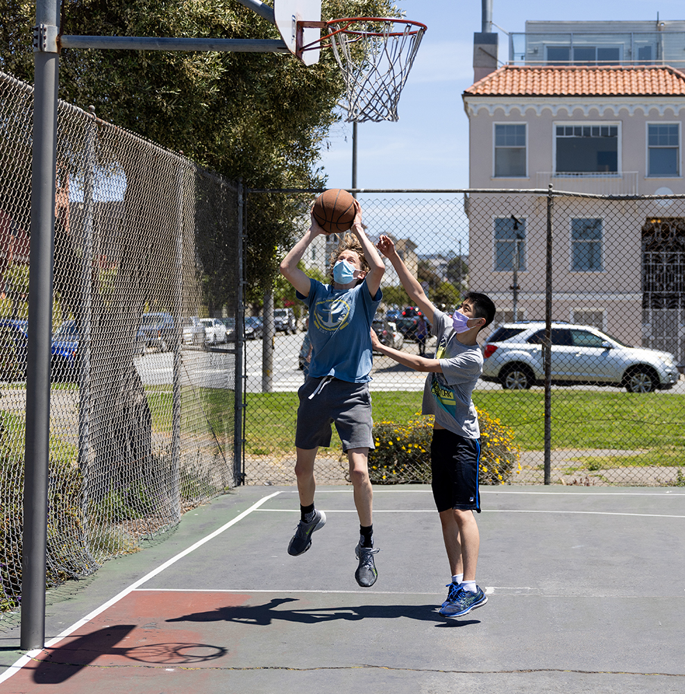 A: Shepard Peterson, 15, shoots a basketball while playing with his friend, Joshua, 14, at a park on Laguna Street. Joshua isolated himself from the public during the height of the pandemic to avoid becoming sick. Now, Joshua and Peterson are thankful for the opportunity to express themselves out in their community.