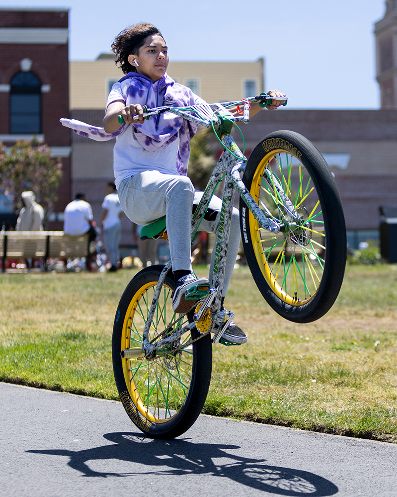 A: Cash Gonzales, 13, does a wheelie on his bike during a gathering at a park along Beach Street near Ghirardelli Square. While Gonzales’ dream is to play basketball in the NBA, he enjoys riding his bike as a way to take his mind off everything else. During the height of the pandemic, he took a break from biking. Now, he says it is “fun and exciting” to bike with others.