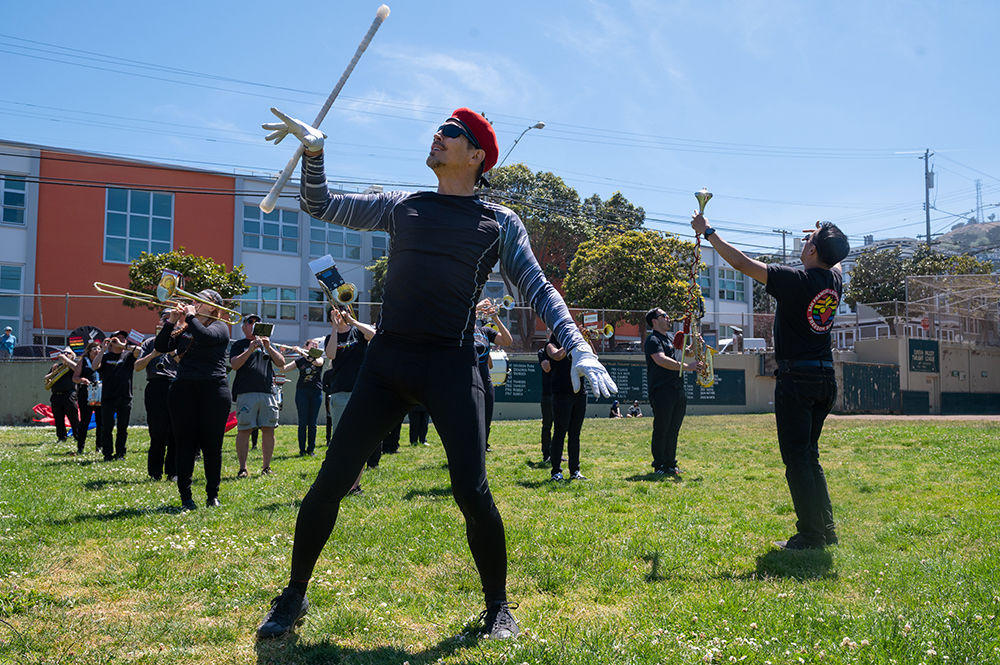 F - Leading the band, Chi Energy, the band’s twirler, practices his marching with the band during a rehearsal at Rikki Streicher Field on Sunday, May 22, 2022 in San Francisco. Chi has been marching and leading the band for years and considers the group some of his good friends getting to spend time with them every week.