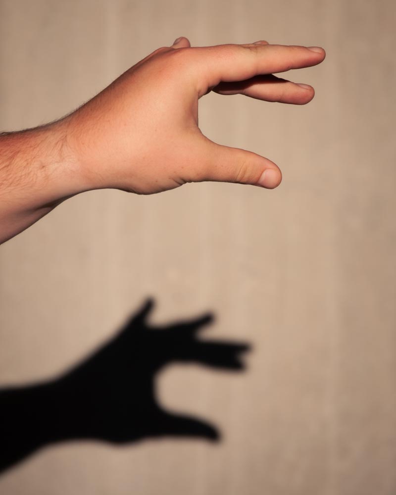 Hand Reaching Out with Shadow in Background