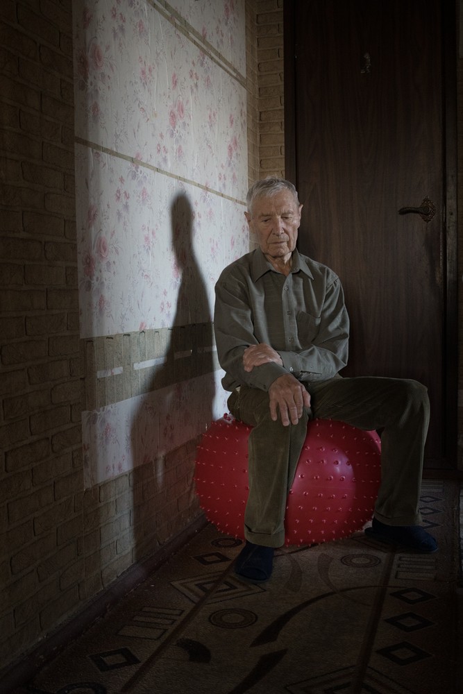 Nikolay is in his apartment sitting on an inflatable ball. With the help of this particular ball, Lidochka and he used to do exercises that the doctor recommended to her. Up to this day, he still does those exercises on a regular basis.