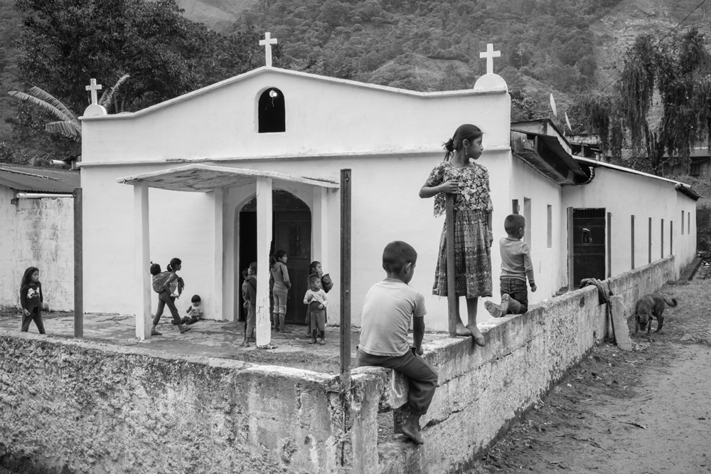 On the first anniversary of the catastrophic landslide that claimed the lives of 58 residents and reduced the village of Queja to ruins, a group of children gathered in front of the old church, one of the few remaining structures in the mostly abandoned village which still bears the scars of the disaster that occurred on November 5th, 2021.