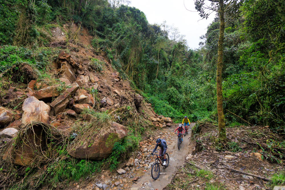 Alex, Emilé and Lucas (left to right) pass the remains of a mudslide on a road outside of Manizales. Such slides are becoming increasingly common on the region’s dirt roads, as climate change intensifies extreme rainstorms that oversaturate the steep hillsides.