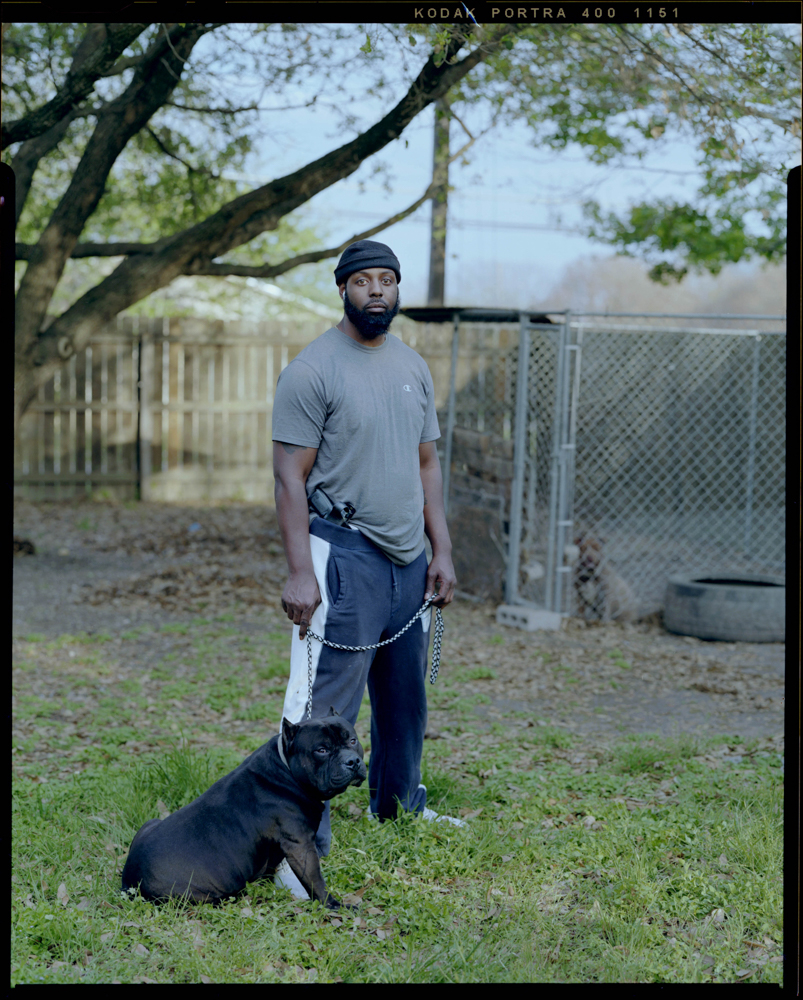 Marvin West, 39, holds his dog outside of his home with his firearm positioned on his hip on Monday, April 06, 2021 in Killeen, Tx. “It’s more to the picture than what you see,” West said. People often judge him based on his appearance. He mentions that those people would be surprised to know that he’s an educated business owner that holds a Masters degree.
