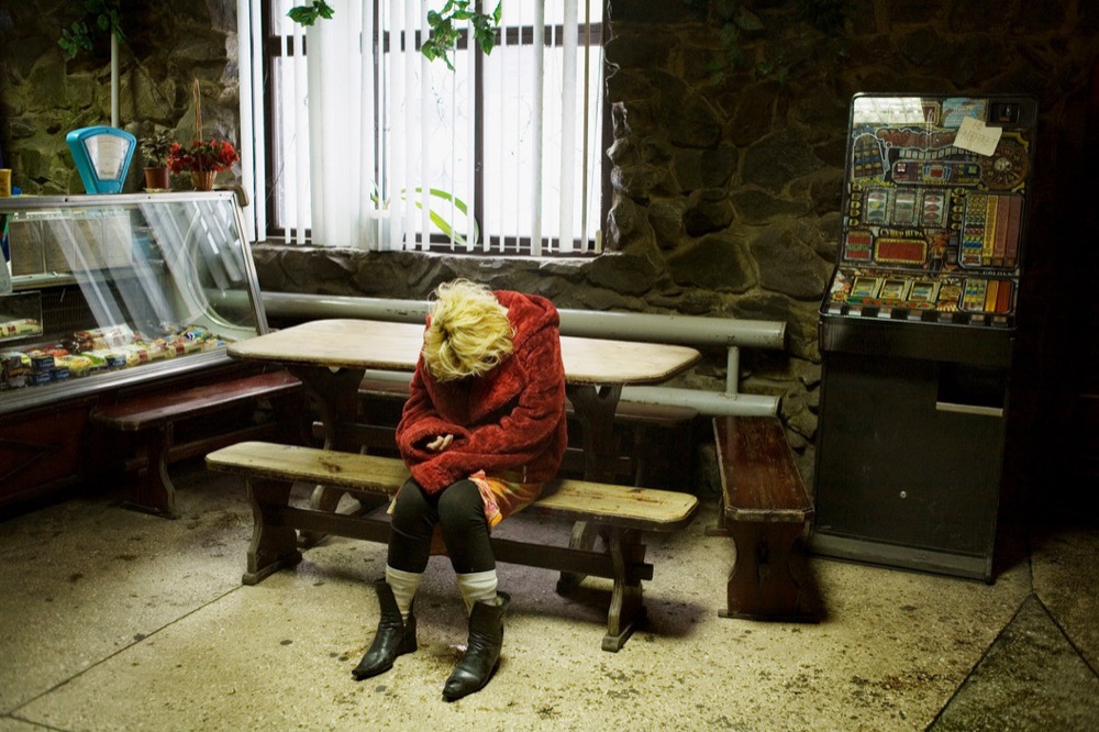 UKRAINE. Torez, Donetsk Oblast. 2007. A young woman high on drugs dozes in a cafe.