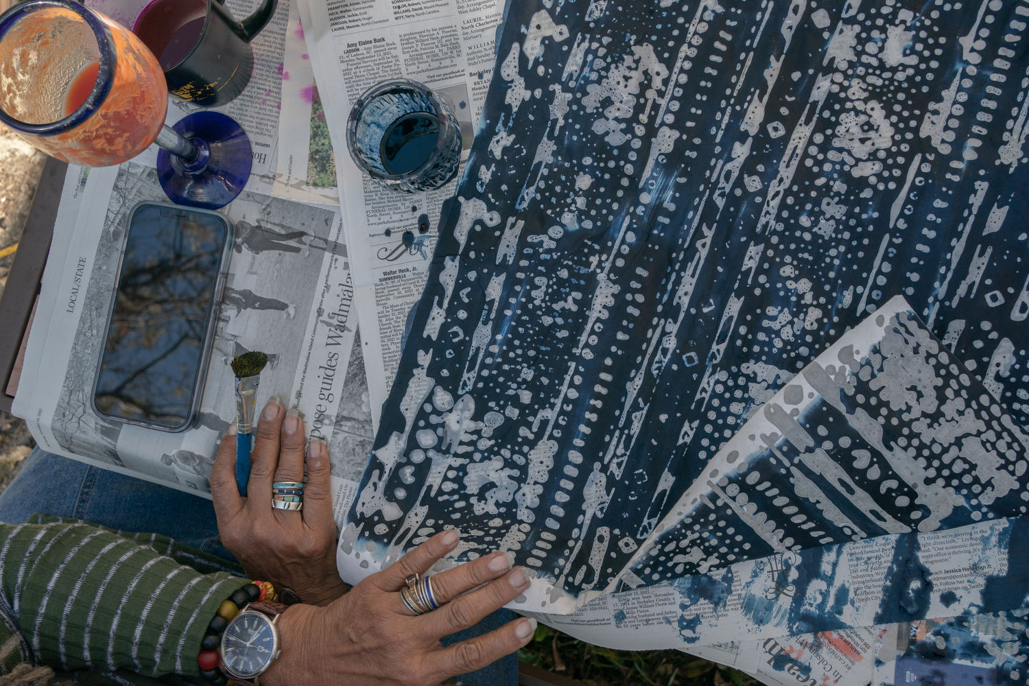Arianne King Comer works on an indigo batik design made on rice paper at Pluff Mudd Farm, in Wadmalaw Island, South Carolina. King Comer uses hot wax dots and lines and brushed on layers of indigo dye to create a pattern.