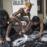 Graphic artist Lin Jiaxi (right) and experimental performance calligrapher Qian Geng (middle) are partners in Three Monkeys Studios, which produces movie posters.   With their friend, Liu Ziheng (left), they also do independent art, like this version of bixian (ghost pen) where only Qian knows what is to be written and physically influences Lin and Liu to write it his way.