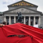 A counter protester is seen peeking out from a banner during a pre-election rally for the Young Alternative for Germany which is affiliated with the far-right party, Alternative for Germany or AfD on Saturday September 22, 2018 in Munich, Germany. (Photo by Matt McClain/ The Washington Post)