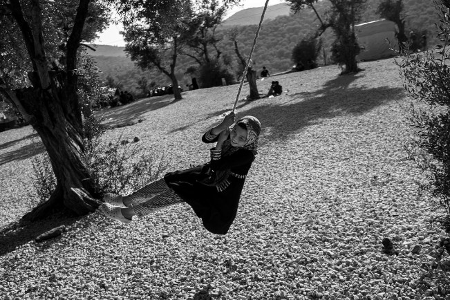 A girl from Afghanistan swings outside Moria refugee camp in the island of Lesbos, Greece. October 20, 2019