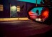 Color night street photograph framed through a car side mirror reflecting red lights and palm trees.