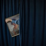 Woman in blue curtain holding picture